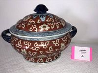 Front side view of antique Asian soup tureen with lid, showing brown and white floral pattern with blue handles and lid knob.