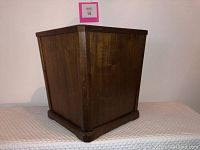 Front and side view of the mid-century modern walnut waste bin showing trapezoidal shape and wood grain finish