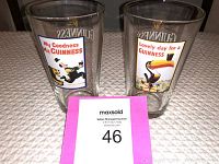 Front view of both Guinness glasses showing colorful vintage graphics.
