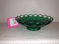 Side angled view of dark green glass bowl showing open loop rim and geometric texture on the inside base.