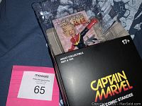 Photo showing Captain Marvel adult collectible figure in plastic packaging with black and yellow box.