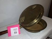 View of the open brass chestnut roaster showing interior and wooden handle.