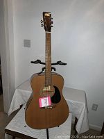 Full front view of the vintage Aspen acoustic guitar showing the wood finish, black pickguard, steel strings, and fretboard.