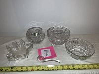 Crystal and leaded glass lot showing footed bowl, medium bowls, leaf-shaped decorative dish, and small glass ladle with measuring tape for scale.