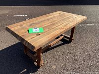 Full view of the rectangular coffee table showing butcher block wooden top and sturdy solid wood base with visible joinery.
