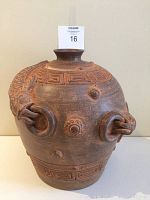 Front view of large pottery vase showing animal head with ring and geometric patterns