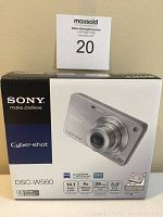 Box of Sony Cyber-shot DSC-W560 camera showing branding and key features including 14.1 Mega Pixels, 4X optical zoom, 26mm wide-angle lens, 3.0 inch LCD screen.