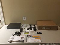 Full lot layout showing DVR unit with accessories including remote, mouse, cables, manual, CD, and stickers arranged on a table.