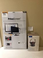 Photo showing unopened Fellowes PrivaScreen privacy filter packaging and Plantronics CT14 cordless headset phone box side by side