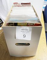 White storage box filled with assorted comic books, with some titles visible including X-Men and Firefight.