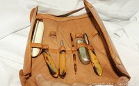 Six-piece vintage manicure set displayed open in leather pouch showing Bakelite-style handles, leather stamped with initials J.H.D.