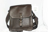 Front view of Ted Baker brown leather messenger bag showing flap and strap buckle detail