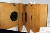 Open album book showing multiple individual sleeves holding vinyl records with visible label 'Decca' on one record.