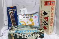 Photo shows boxed games standing upright including Cribbage set in blue packaging, Go Go Gear Art kit in colorful box, Probe game in vintage box, and Bridge for Two in cream box.