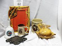 Photo showing the assortment of California souvenir items including the floral photo frame, ceramic pieces, coffee mug, and bell.
