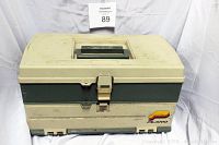 Closed beige and green Plano fishing tackle box featuring a top carrying handle and front latch.