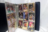 Photo showing two page sleeves of NBA basketball trading cards featuring players in various poses, inside a black binder.