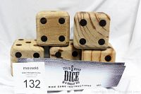 Five large wooden dice arranged in a pyramid with visible black dot pips, showing natural wood grain and color variations.
