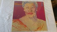 Front cover of the double vinyl album featuring Ella Fitzgerald portrait with bright abstract strokes on red and beige background.