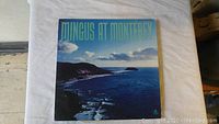 Front cover of 'Mingus At Monterey' vinyl album showing ocean coast and sky