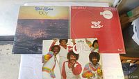 Three Chi-Lites vinyl records shown on a white cloth surface, featuring albums 'Toby','Half A Love' and 'The Fantastic Chi-Lites'.