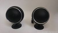 Front view of two spherical orb speakers on stands
