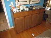 Front view of wood buffet showing drawers, doors, Formica top with wear, and decorative items on top (not included).