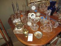 Overall view of table showing quartz clocks, crystal glassware, and decorative items
