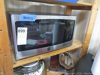 Front view of Kenmore microwave showing stainless steel finish and interior with visible paper towel roll inside.