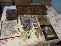 Wide view of bed covered by floral quilt with religious wall art and basket items arranged on top
