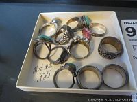 All rings grouped in a small box showing varied designs and sizes.