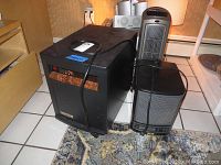 Eden Pure heater, Lasko heater and Lasko air purifier side by side on tile floor beside wooden cabinetry and patterned rug