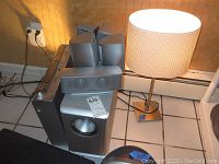 Panasonic speakers, subwoofer, VHS/DVD combo player on floor next to one of the lamps