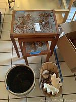 Two tile topped nesting tables, largest approximately 20x15x19, showing cracks and chips on tiled surface. Large two tone number 4 crock in foreground.
