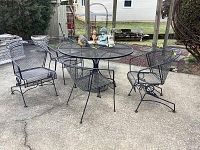 Full view of round table with four chairs and decor items on tabletop