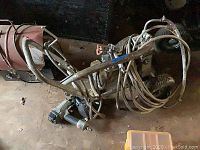 Paint sprayer and air staple gun viewed from above, showing hoses and handle
