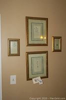 Three botanical prints in gold-tone frames hanging on wall