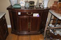 Front view of Bernhardt wooden buffet showing silverware drawer and cabinet doors with brass handles, dark wood finish.