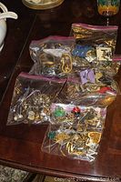 Plastic bags with assorted earrings in various styles and finishes on table
