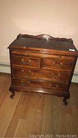 Wooden end table by Century Furniture Company with four drawers, dark finish, brass hardware, and shaped legs.