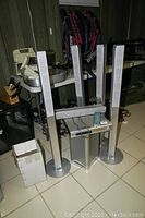 Sony 5.1 surround sound speaker setup with four tall tower speakers, center channel speaker, subwoofer and amplifier visible in basement setting.