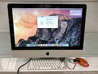 Front view of iMac computer powered on with keyboard and mouse