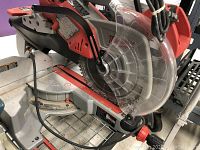 Side view showing saw body, sliding mechanism, base and cord