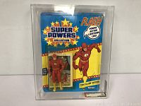 Front view of the Flash action figure sealed in original packaging with comic book insert and vibrant card art.