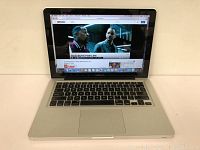 Open MacBook Pro powered on; display shows YouTube on OS X Yosemite