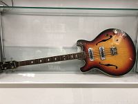 Full length of sunburst semi-hollow bass laid horizontally