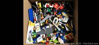 Top view of the box filled with assorted LEGO pieces including bricks, plates, and minifigures