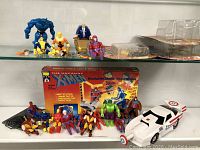 Full lot of Marvel action figures displayed on shelves along with the Marvel X-Men themed playset box and white vehicle.