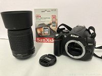 Overview showing camera body, lens, front cap, memory card packaging