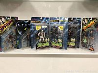 Front view of all six Spawn action figures in original blister packages displayed together on a white shelf.